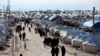 FILE - People walk through al-Hol displacement camp in Hasaka governorate, Syria, April 1, 2019. Northeastern Syria is home to several displaced-person and refugee camps.