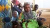 FILE - A family of refugees that fled their homes due to violence from the Islamic extremist group Boko Haram sit inside a refugee camp in Minawao, Cameroon, Feb. 25, 2015.