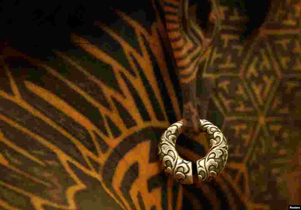 An earring is pictured on a man with tattoos on his face and neck during the Nepal Tattoo Convention in Kathmandu, Nepal.