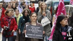An activist holds a sign as she attends a demonstration a day after the French Constitutional Council decided the immediate repeal of the law on sexual harassment, in Paris, May 5, 2012. 