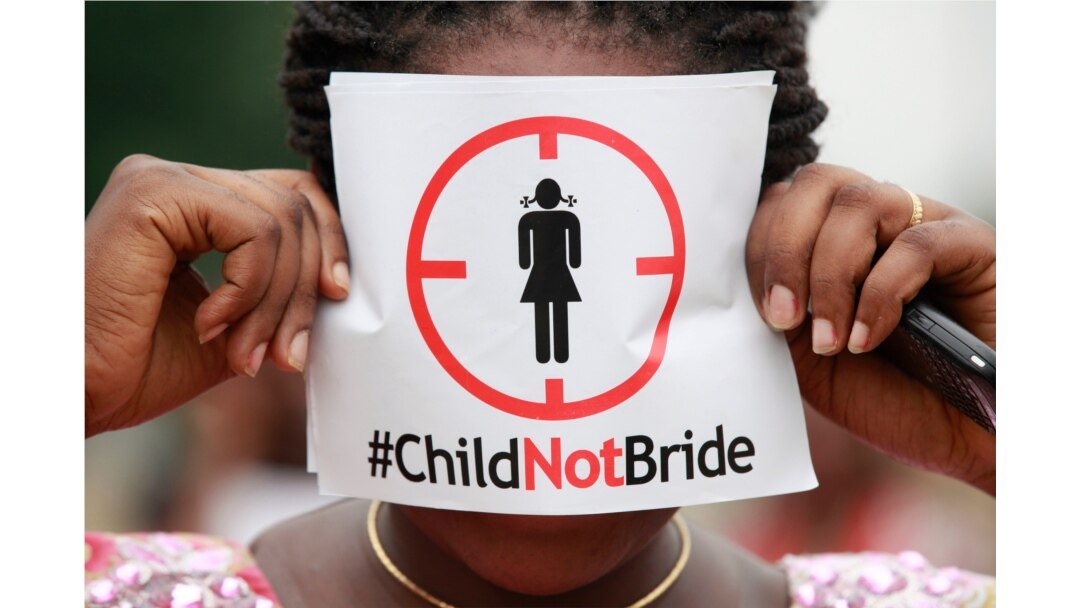 FILE- In this July 20, 2013, file photo, a woman protests against underage marriage in Lagos, Nigeria.