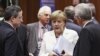 European Central Bank (ECB) President Mario Draghi (L) and Italy's Prime Minister Mario Monti (R) listen to Germany's Chancellor Angela Merkel during a European Union leaders summit in Brussels June 29, 2012.