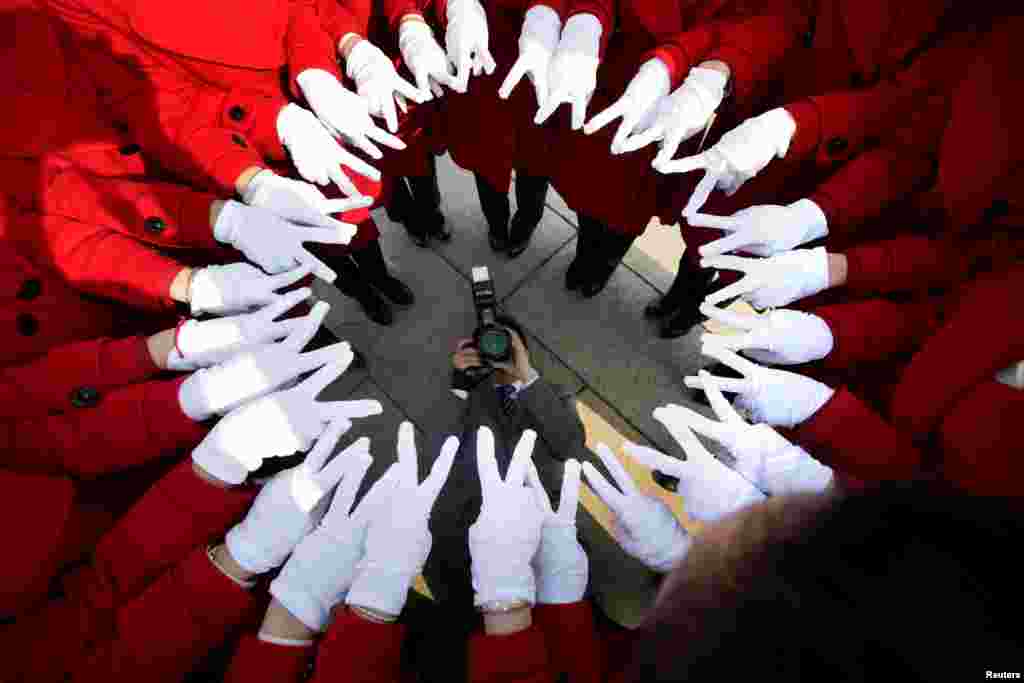 Attendants serving delegates pose for a photo at Tiananmen Square as delegates attend a meeting during the annual session of China's parliament, the National People's Congress (NPC), in Beijing, March 4, 2017.