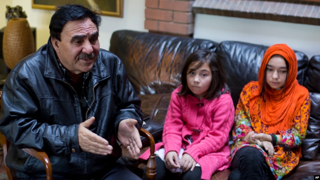 In this Nov. 29, 2018 photo, Mir Aman speaks to The Associated Press with his daughters Shahnaz, right, and Shakeela, in Islamabad, Pakistan.