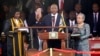 Kenya's President Uhuru Kenyatta takes the oath of office as his wife Margaret holds a bible during the official swearing-in ceremony at Kasarani Stadium in Nairobi, April 9, 2013. 