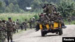 M23 rebel fighters sit on a truck as they prepare to withdraw near the town of Sake, 42 kilometers west of Goma in eastern Congo, November 30, 2012.