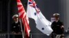 FILE - Crew members from the Japanese Maritime Self-Defense force ship Umigiri stand on deck between Japan's Self-Defense Force flag alongside an Australian flag before joint exercises at Garden Island Naval Base in Sydney, April 19, 2016. 