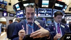 미국 경제의 중심지 월스트리트에 있는 뉴욕증권거래소(NYSE) 관계자들이 지난달 말 장중 시황을 점검하고 있다. 