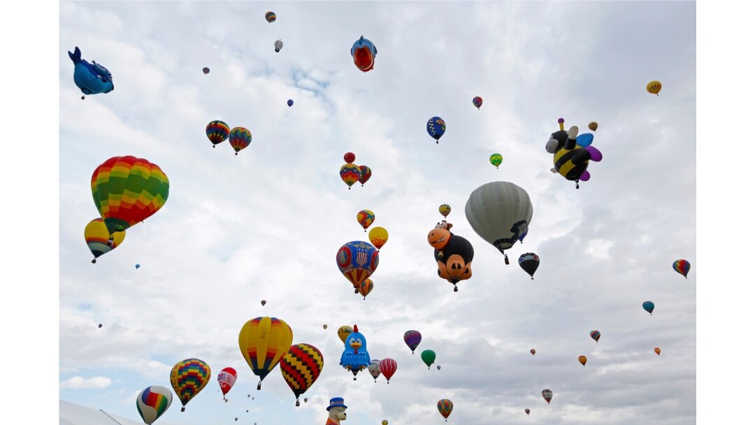 FILE - Hot air balloons fly during the 44th Albuquerque International Balloon Fiesta in Albuquerque, N.M., Oct. 4, 2015.