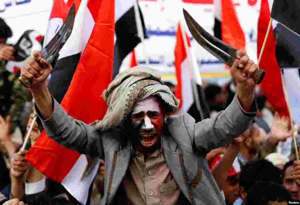 A man waves traditional daggers, or Jambiyas, as he attends with supporters of the Houthi movement and Yemen's former president Ali Abdullah Saleh a rally to mark two years of the military intervention by the Saudi-led coalition, in Sana'a, Yemen.