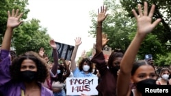 FILE - A demonstrator holds a placard reading "Racism Kills" during a Black Lives Matter protest in Berlin, Germany, July 2, 2021.