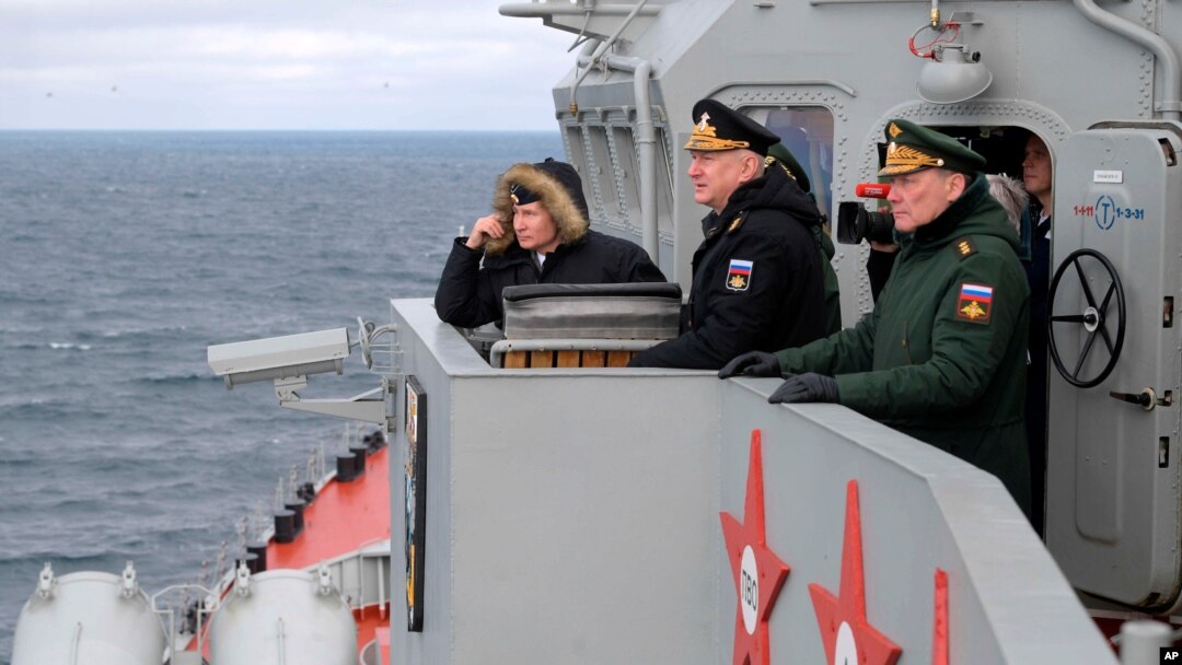 FILE -Russian President Vladimir Putin, left, and Russian navy officials watch a navy exercise from from a missile cruiser in the Black Sea, Crimea, Jan. 9, 2020.