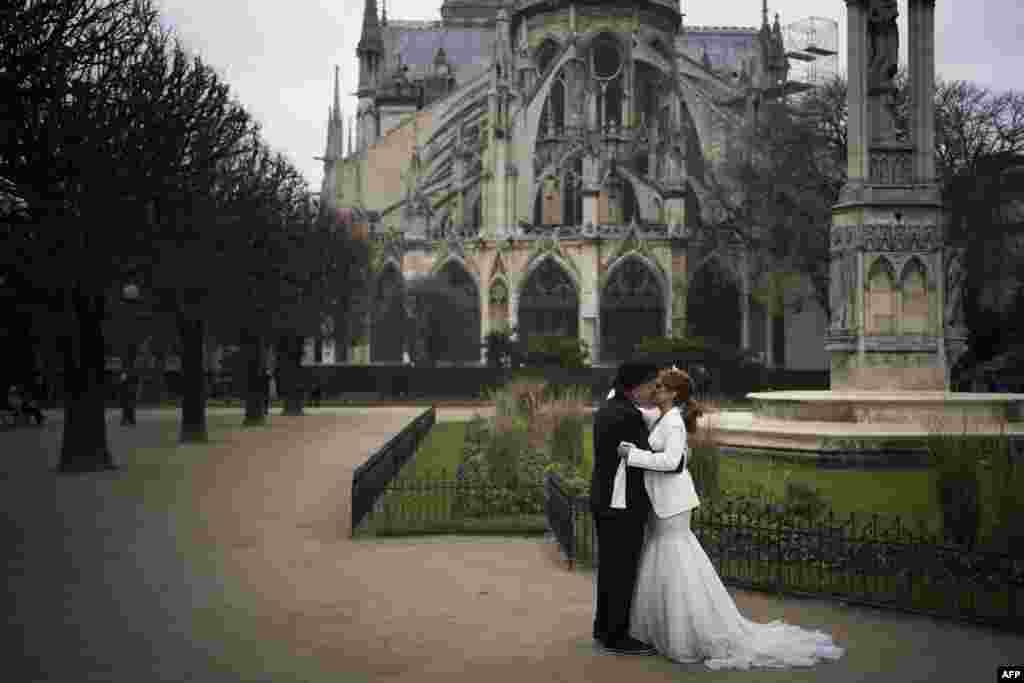 A couple kisses after renewing their vows behind Notre-Dame Cathedral in Paris, France, on Valentine's Day.