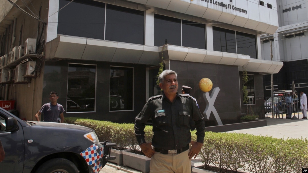 Pakistani police officer stands guard at the office of Axact software company in Karachi, May 27, 2015.