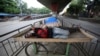 Homeless men sleep on a handcart parked on a road divider in a containment zone during lockdown in Bengaluru, India, July 5, 2020. 