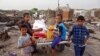FILE - Internally displaced Yemenis whose camp was ravaged by fire two days earlier receive food aid in the village of al-Durayhimi, on the southern edge of the flashpoint Red Sea port city of Hodeida, July 19, 2021. 
