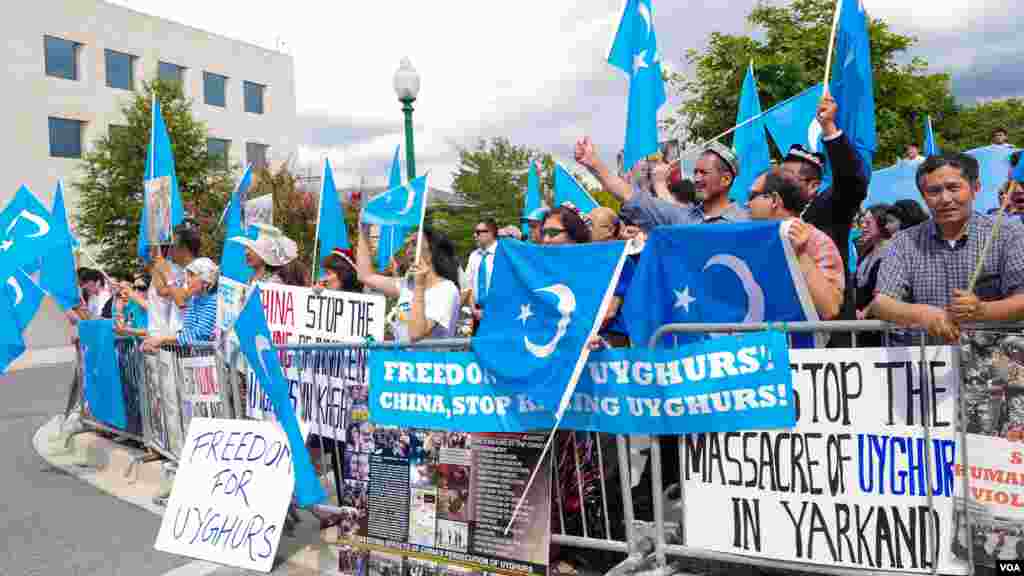Uyg'urlar Sharqiy Turkiston bayroqlarini ko'tarib, Xitoy elchixonasi qarshisida bu davlatning uyg'urlarga qarshi siyosatini qoralab, namoyish qilmoqda, Vashington, 3-avgust, 2014-yil. Odil Ruzaliev surati
