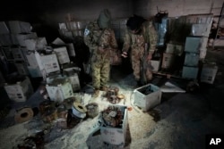 Syrian rebels inspect electrical components used to hide Captagon amphetamine pills at a facility in Douma city, outskirts of Damascus, Syria, Dec. 13, 2024.