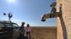 FILE - Farmers Matt and Sandra Ireson on their property, Sept. 28, 2018, during a severe and prolonged drought outside the town of Booligal in western New South Wales. 