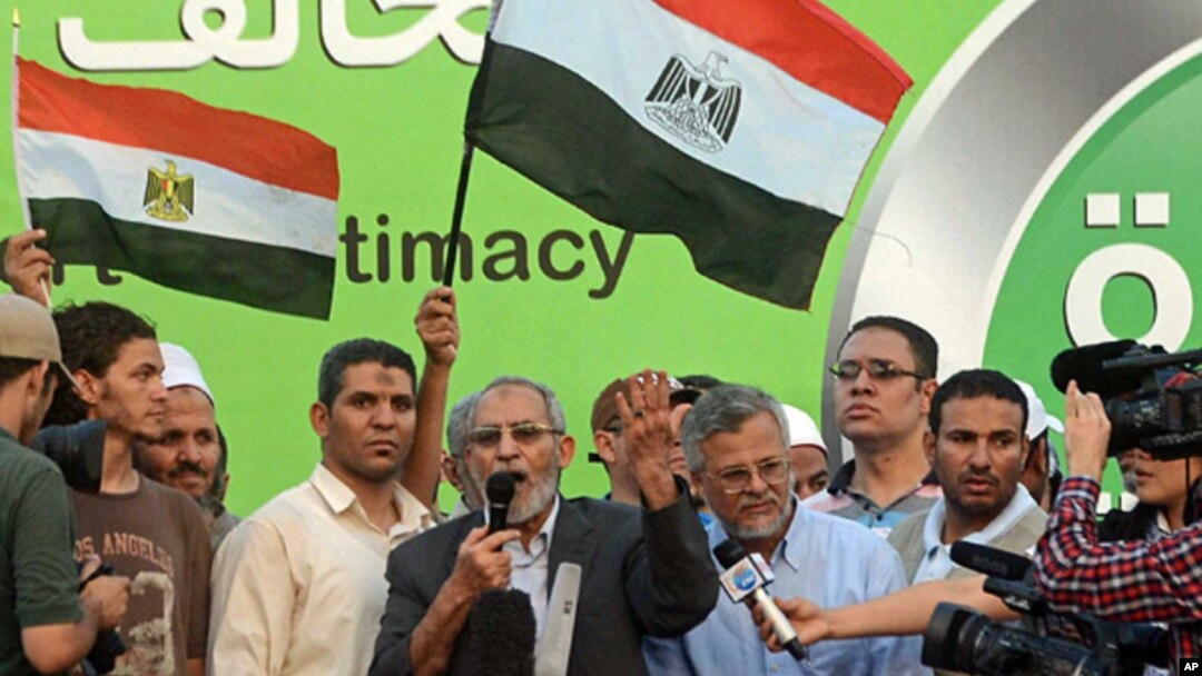 The Muslim Brotherhood's General Guide Mohammed Badie speaks onstage as military helicopters fly overhead before tens of thousands of supporters in Cairo, Egypt, July 5, 2013.