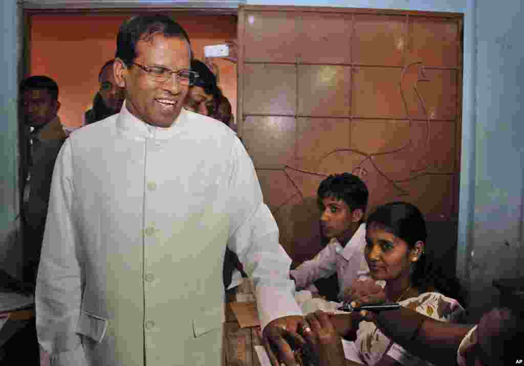 Sri Lanka's main opposition presidential candidate Mithripala Sirisena gets his finger marked with indelible ink after casting his vote at a polling station in Polonnaruwa, about 200 kilometers northeast of Colombo, Sri Lanka, Jan. 15, 2015. 