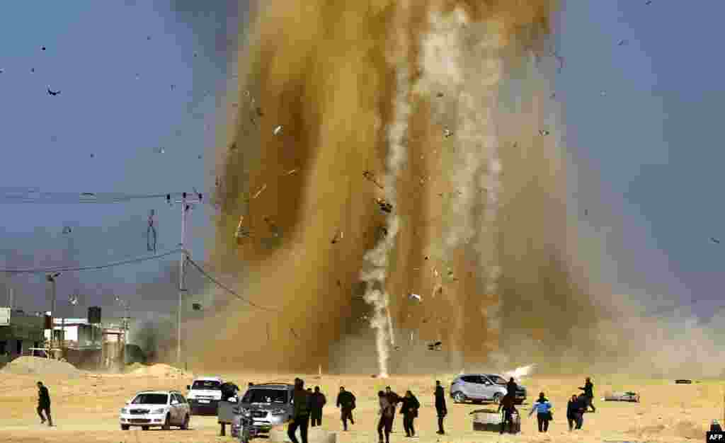 Palestinians run for cover as smoke rises following an Israeli airstrike on a Hamas post, in the northern Gaza Strip. Israel struck a number of Hamas positions in Gaza after a "projectile" fired from the Palestinian enclave crashed in a border area, the Israeli army said.