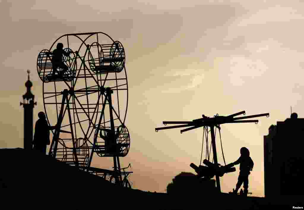 Afghan children play on a manually operated ferris wheel in Kabul.