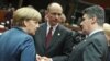 German Chancellor Angela Merkel, left, talks with Croatia's Prime Minister Zoran Milanovic, right, and Italy's Prime Minister Enrico Letta, during an EU summit at the European Council building in Brussels, Belgium, Dec. 19, 2013. 
