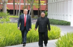 FILE - In this photo taken June 12, 2018, and released by North Korea's official Korean Central News Agency (KCNA), North Korea's leader Kim Jong Un (R) walks with U.S. President Donald Trump (L) during a break in talks at their summit in Singapore.