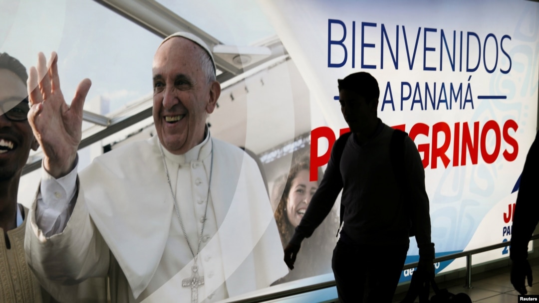 A passenger walks past a poster of Pope Francis at the Tocumen International Airport ahead of Pope Francis' visit for World Youth Day, in Panama City, Panama, Jan. 21, 2019.