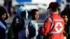 Migrants stand in a line in front of Red Cross member after disembarking from the Italian navy ship Borsini in the Sicilian harbor of Palermo, southern Italy, July 20, 2016.