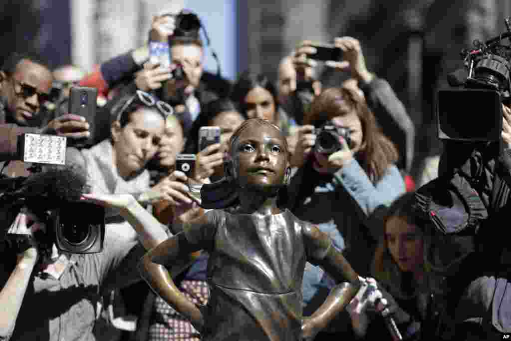 People stop to photograph the "Fearless Girl" statue in New York.