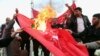 Protesters burn a Turkish flag during a demonstration calling for the withdrawal of Turkish troops from northern Iraq, in Basra, Iraq, Dec. 18, 2015.