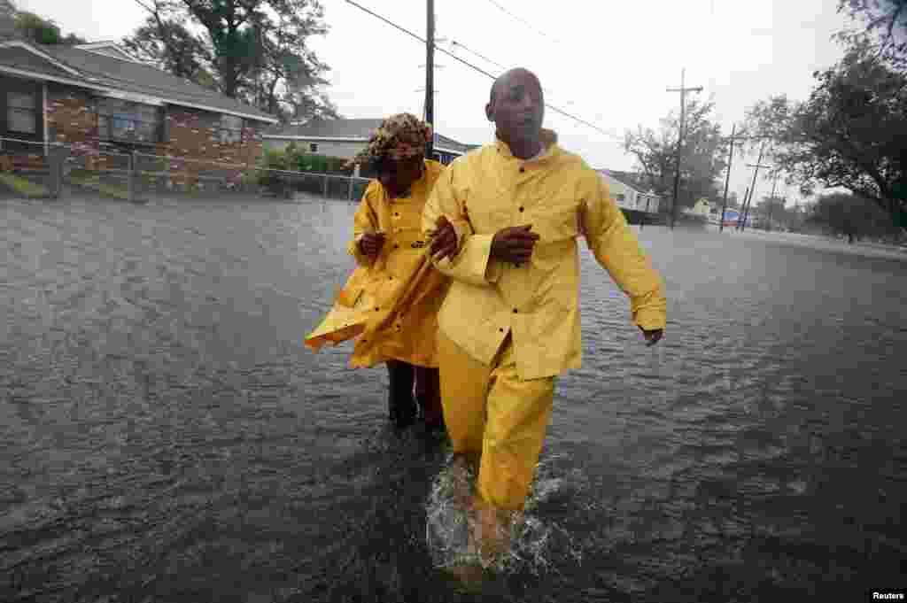 A man and a woman walk through flood waters on St. Roch ave. as Hurricane Isaac makes land fall in New Orleans, Louisiana August 29, 2012.