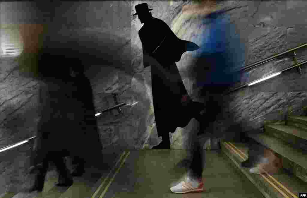 Passengers walk down the stairs at Dostoyevskaya metro station in Moscow, Russia.