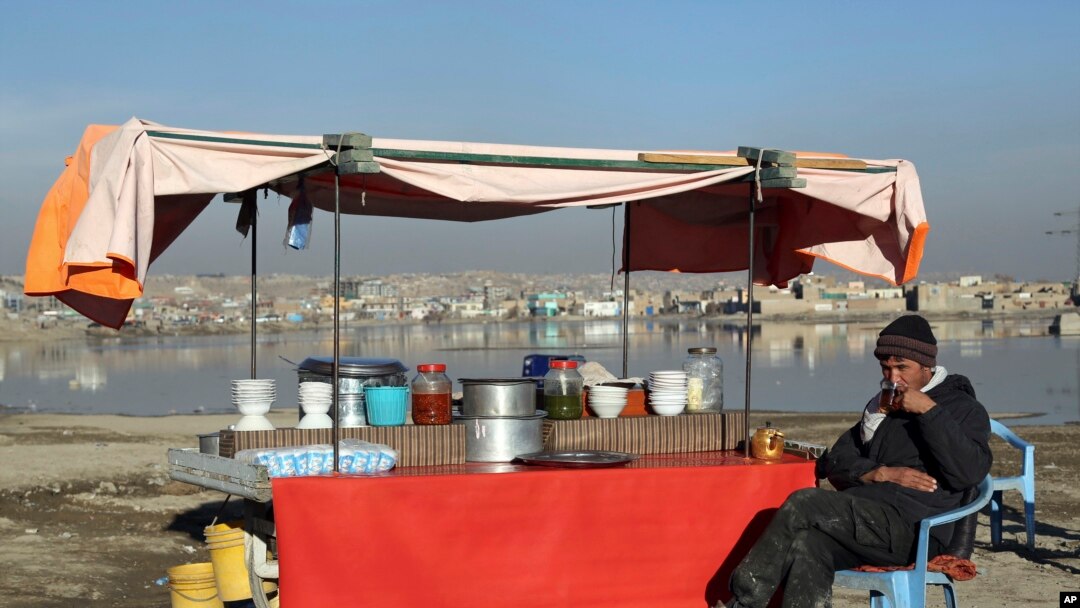 FILE - In this Jan. 28, 2019 file photo, an Afghan street vendor waits for customers on the outskirts of Kabul, Afghanistan. 