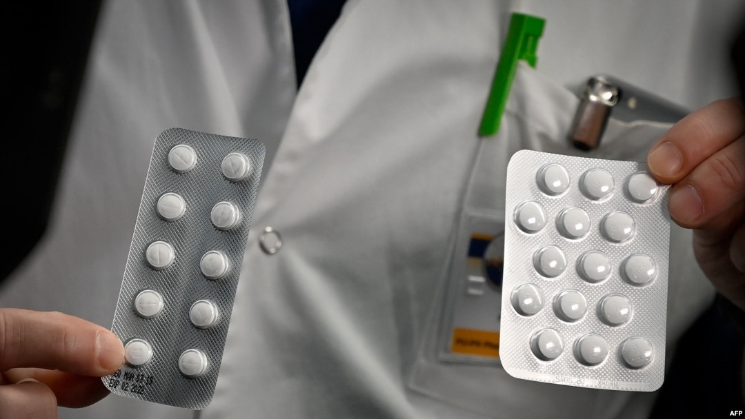 FILE - In this photo taken on Feb. 26, 2020, medical staff at the IHU Mediterranee Infection Institute in Marseille, France, show packets of Nivaquine, tablets containing chloroquine and Plaqueril, tablets containing hydroxychloroquine. 