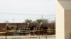 FILE - A group of people are detained by Border Patrol agents on horseback after crossing the border illegally from Tijuana, Mexico, near prototypes for a border wall, right, being constructed in San Diego, Calif., Oct. 19, 2017.