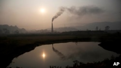 FILE - Smoke rises from a brick kiln on the outskirts of Gauhati, India, Jan. 26, 2015.