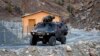 FILE - A Turkish military armored personnel carrier drives past a small patrol base in the mountains of Cukurca in southeastern Turkey, near the Iraqi border, Oct. 21, 2011.
