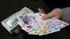 A money changer holds Turkish lira banknotes next to U.S. dollar bills at a currency exchange office in central Istanbul, April 15, 2015. 