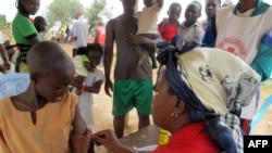 FILE - A child receives a measles vaccine in a camp set up by the UNHCR in Nangungue, Cameroon, April 12, 2013.