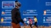 People walk past a COVID-19 advertisement in the township of Soweto outside of Johannesburg, South Africa, July 13, 2020.