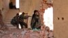 Kurdish People's Protection Units (YPG) fighters take up positions inside a damaged building in al-Vilat al-Homor neighborhood in Hasaka city, as they monitor the movements of Islamic State fighters, July 22, 2015.