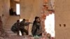 FILE - Kurdish People's Protection Units (YPG) fighters take up positions inside a damaged building in al-Vilat al-Homor neighborhood in Hasaka, Syria, as they monitor the movements of Islamic State fighters, July 22, 2015.