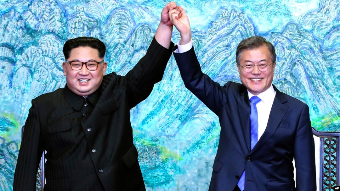 North Korean leader Kim Jong Un, left, and South Korean President Moon Jae-in raise their hands after signing a joint statement at the border village of Panmunjom in the Demilitarized Zone, South Korea, April 27, 2018.