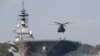FILE - A helicopter lands on the Izumo, Japan Maritime Self Defense Force's (JMSDF) helicopter carrier, at JMSDF Yokosuka base in Yokosuka, south of Tokyo, Japan, Dec. 6, 2016. 
