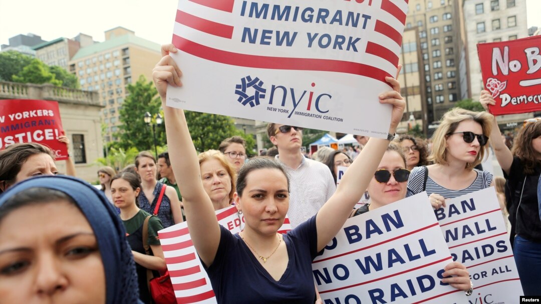 FILE PHOTO: Protesters hold signs against U.S. President Donald Trump's limited travel ban, approved by the U.S. Supreme Court, in New York City, on June 29, 2017.