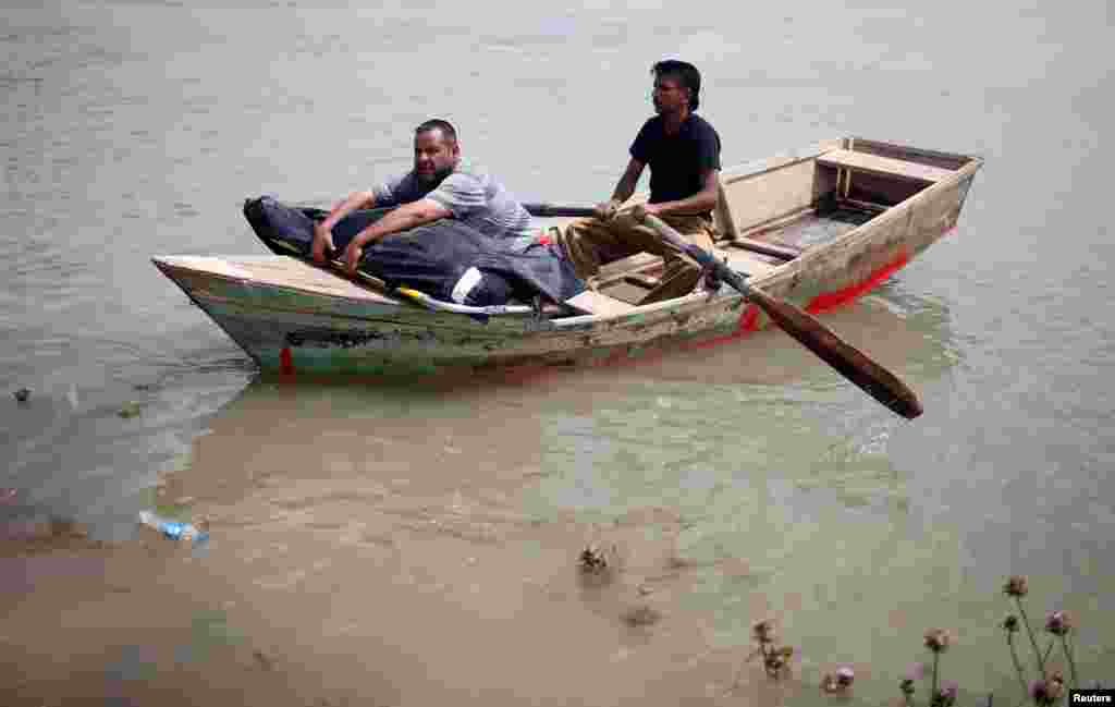 A displaced Iraqi holds the body of his wife, who was killed during the fighting in Mosul, on a boat sailing to cross the Tigris River after the bridge has been temporarily closed, in western Mosul, May 6, 2017.