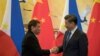 FILE - Philippine President Rodrigo Duterte (L) and Chinese President Xi Jinping shake hands after a signing ceremony held in Beijing, Oct. 20, 2016. 